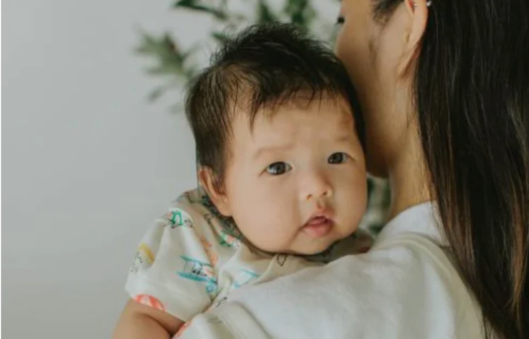 mom holding baby in summer sleepwear