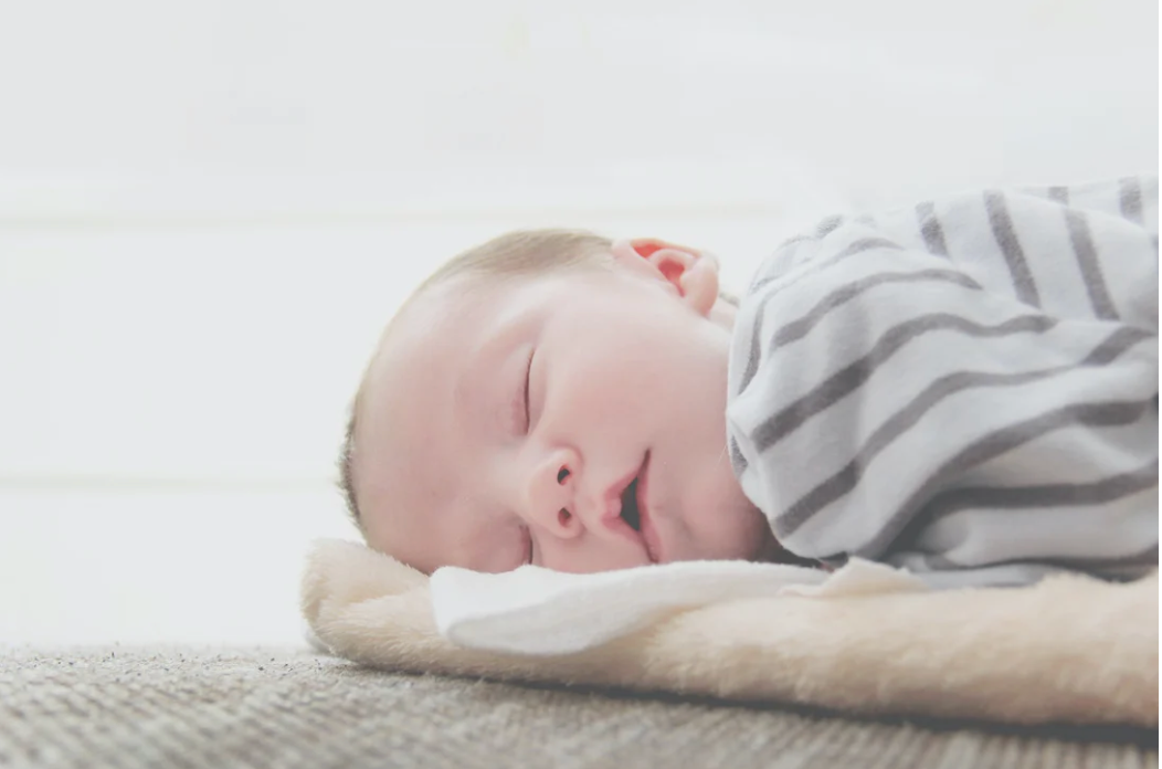 baby in stripey swaddle asleep