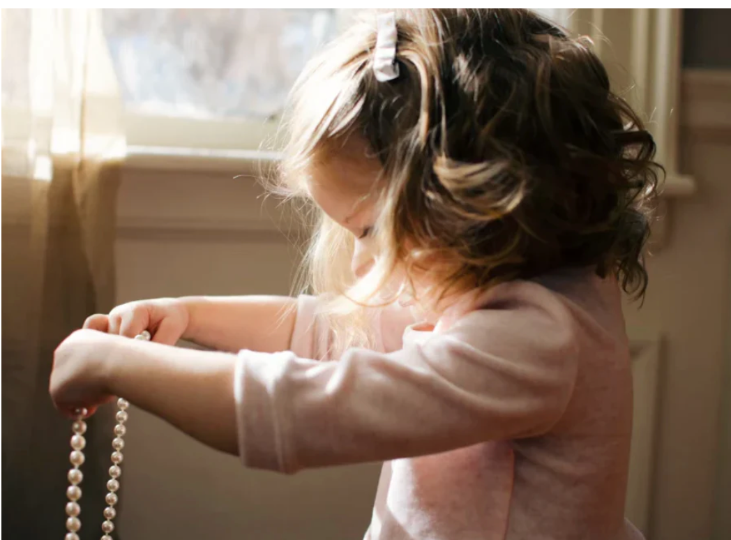 children's fashion child holding jewelry