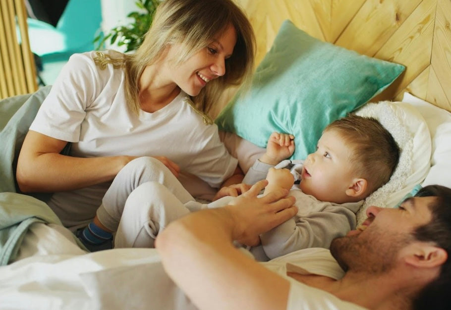 mom and dad with baby in bed