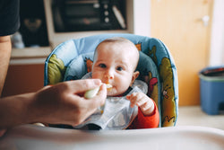 Child eating food in baby chair